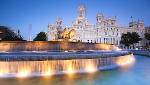 A grand historic building with a large fountain in the foreground.