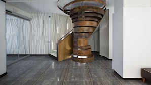 A modern interior with a spiral staircase, a patterned wall, and a minimalist design.