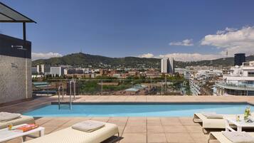 Een buitenzwembad en ligstoelen