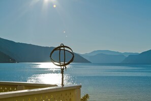 A lake with mountains in the background and a sun reflecting on the water. - Kviknes (Sogndal)