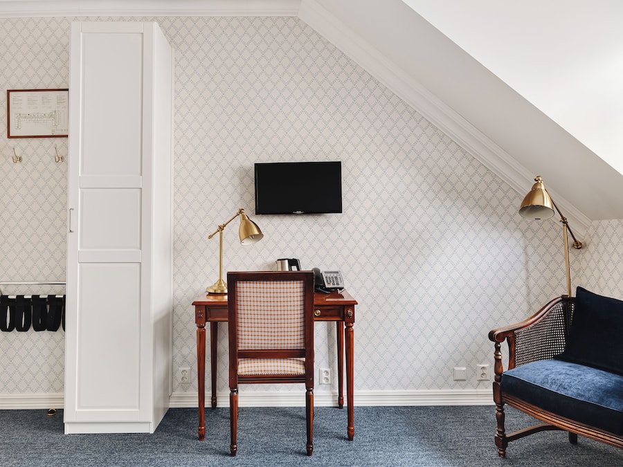 Ein Zimmer mit Schreibtisch, Stuhl und Fernseher an der Wand.
