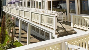 A multi-story building with balconies, a covered walkway, and a view of the water.