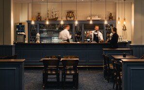 A bar area with a counter, bar stools, and a seating area with tables and chairs.