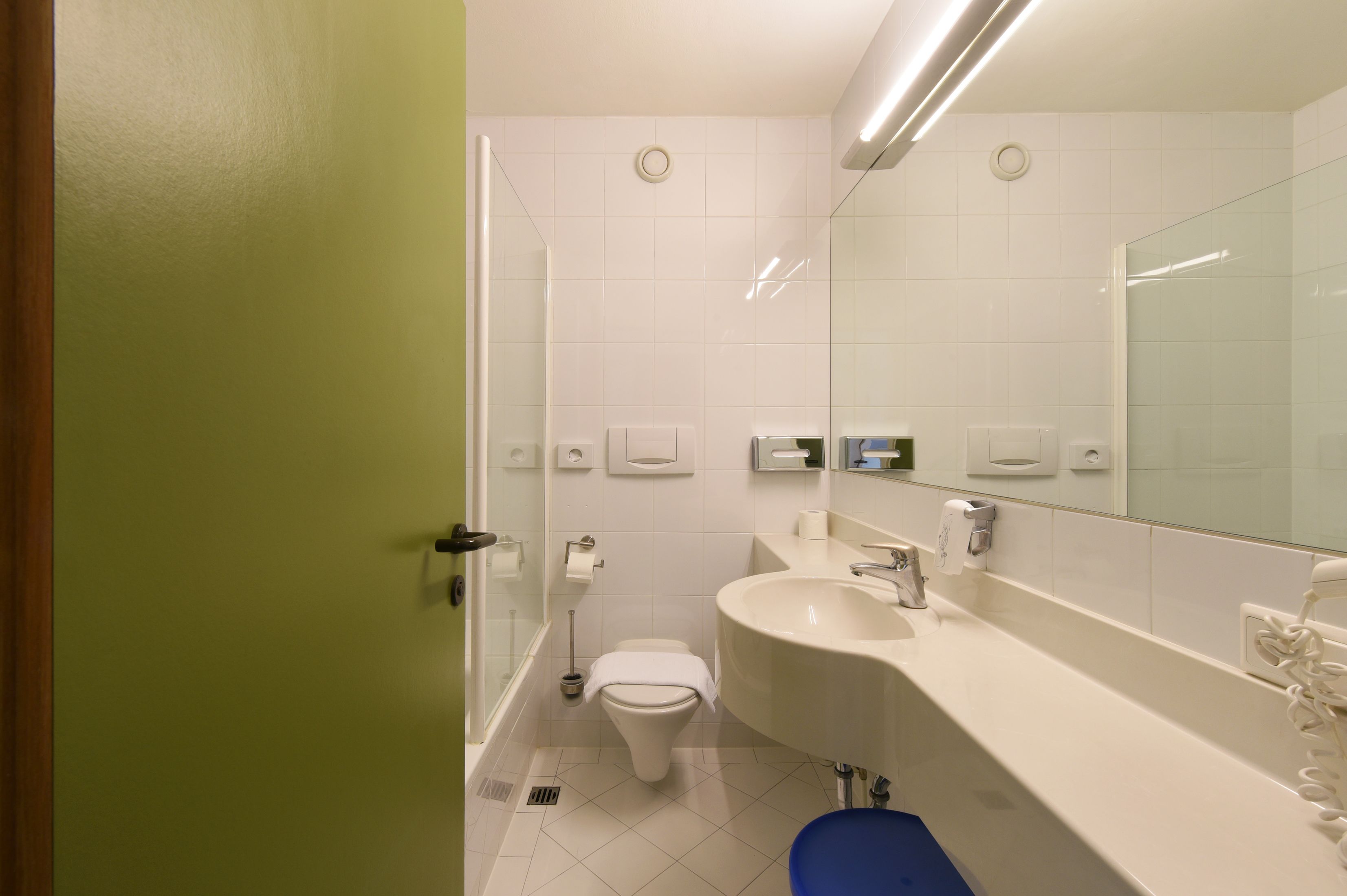 Un baño moderno con inodoro, lavabo y cabina de ducha de vidrio.