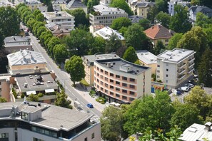 An aerial view of a residential area with multi-story buildings, a main road, and surrounding greenery. - Am Neutor Hotel Salzburg Zentrum (Salzburg)