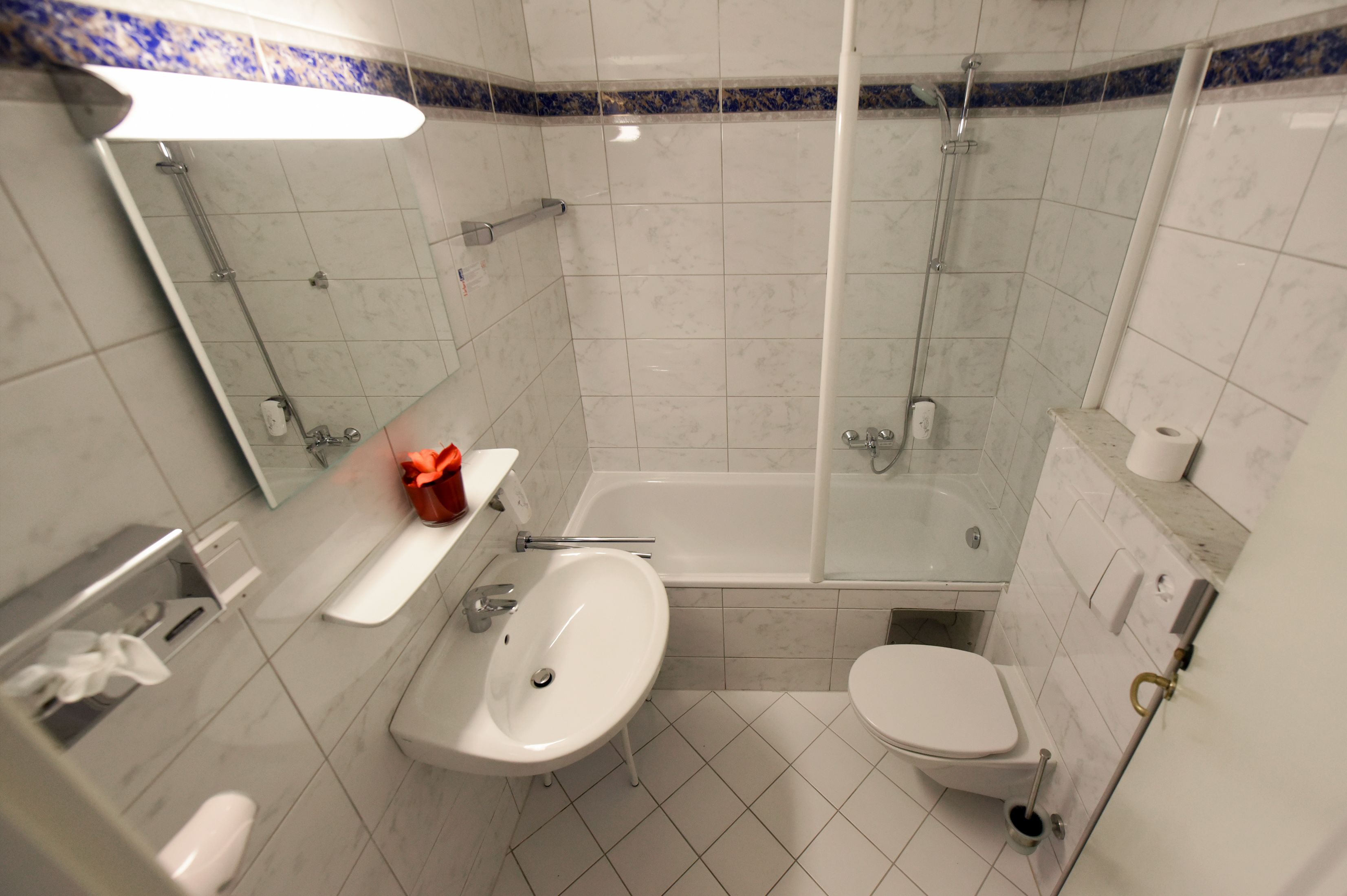 Ein Badezimmer mit Badewanne, Waschbecken, Toilette und Spiegel.
