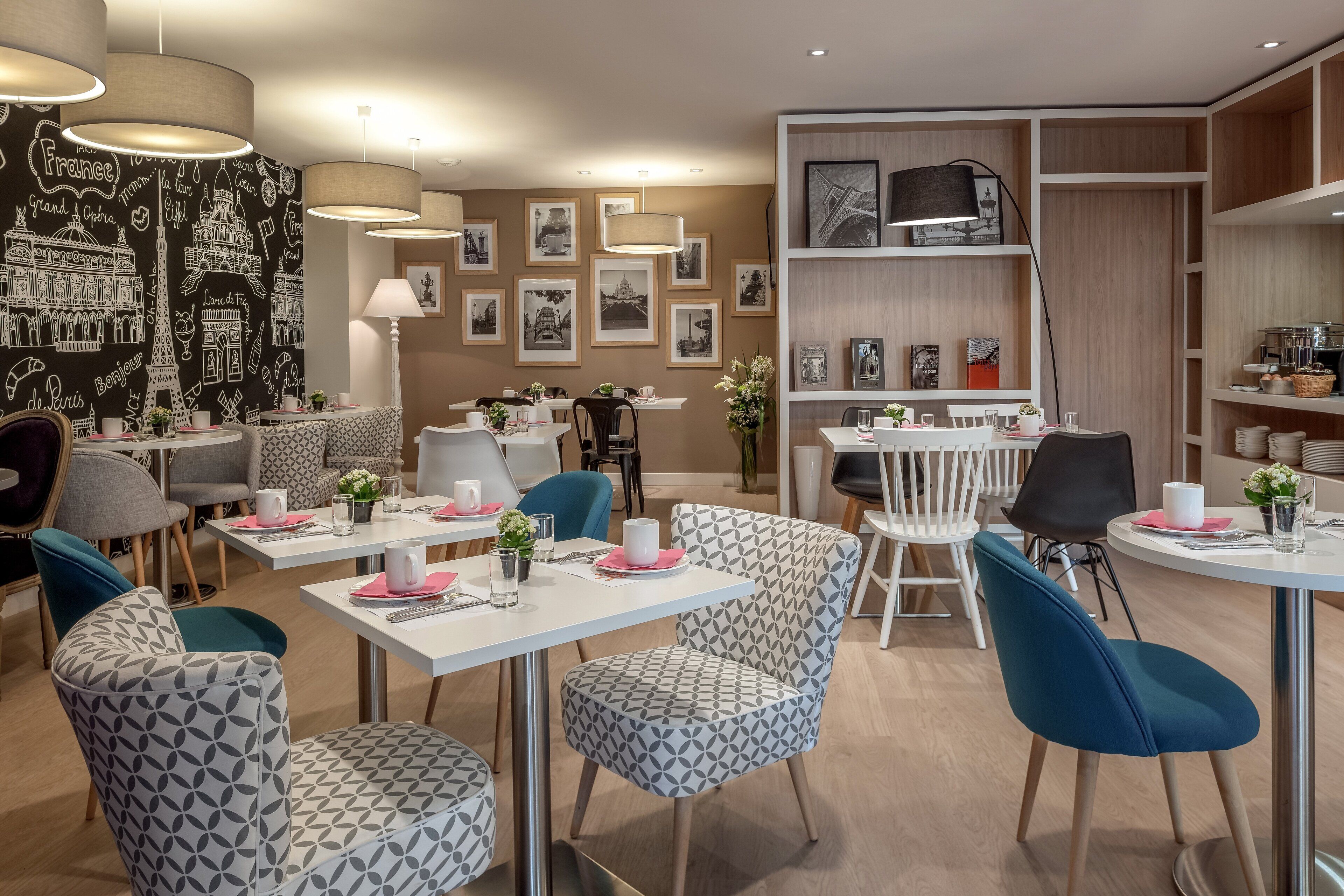 A modern dining area with patterned chairs, tables, and a wall decorated with black and white cityscape prints.