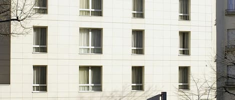 A multi-story hotel with a flat facade, numerous windows, and a sign indicating it is a hotel.