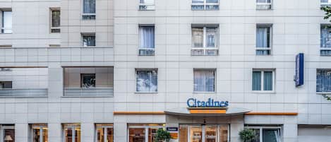 Un hotel con fachada moderna, múltiples ventanas y un llamativo letrero de 'Citadines'.