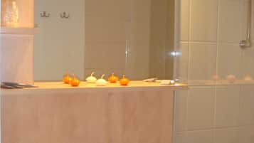 Un baño con lavamanos, espejo y ducha.