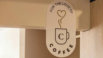Een rond bord met een koffiekop en stoom, wat een koffie gerelateerde dienst of thema aangeeft.