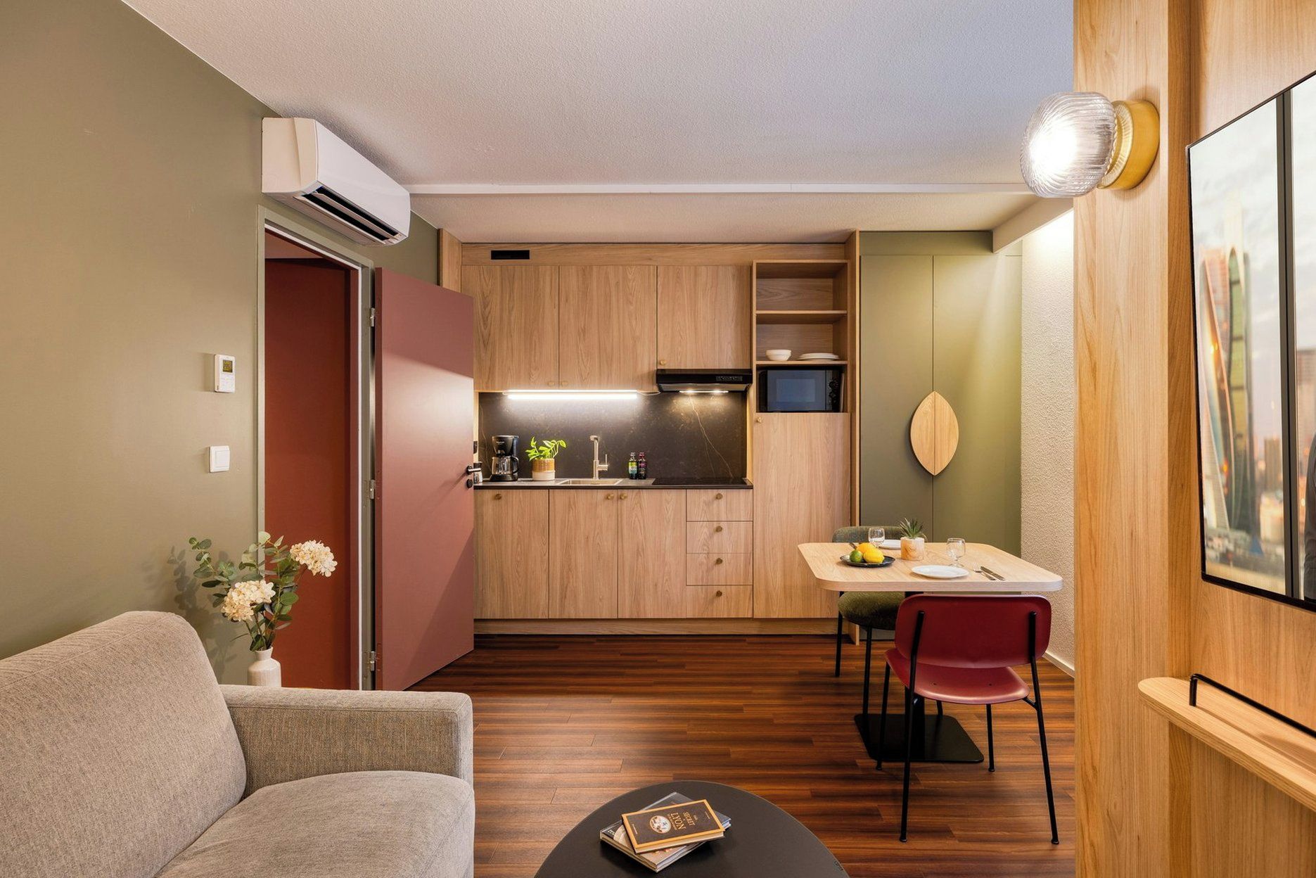 A compact living space with a kitchenette, a dining area, and a seating area.