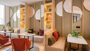 A modern interior with a sectional sofa, a round table, and built-in bookshelves.