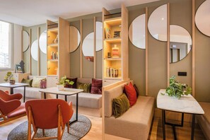 Un interior moderno con un sofá modular, una mesa redonda y estanterías empotradas.