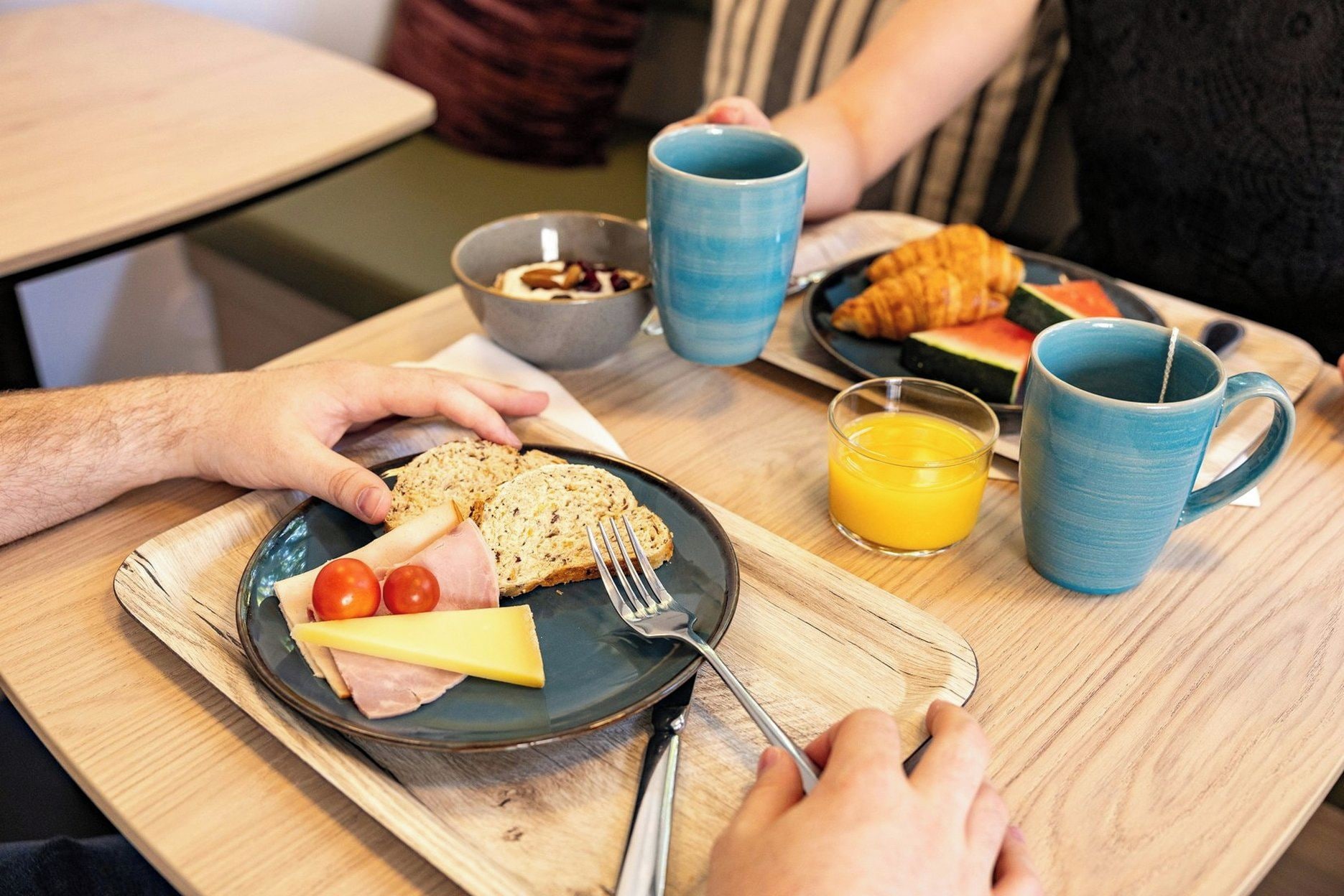 En frukostuppsättning med en tallrik mat, en mugg och ett glas apelsinjuice.
