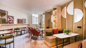 A modern living room with a sofa, chairs, a coffee table, and a dining area with a table and chairs.