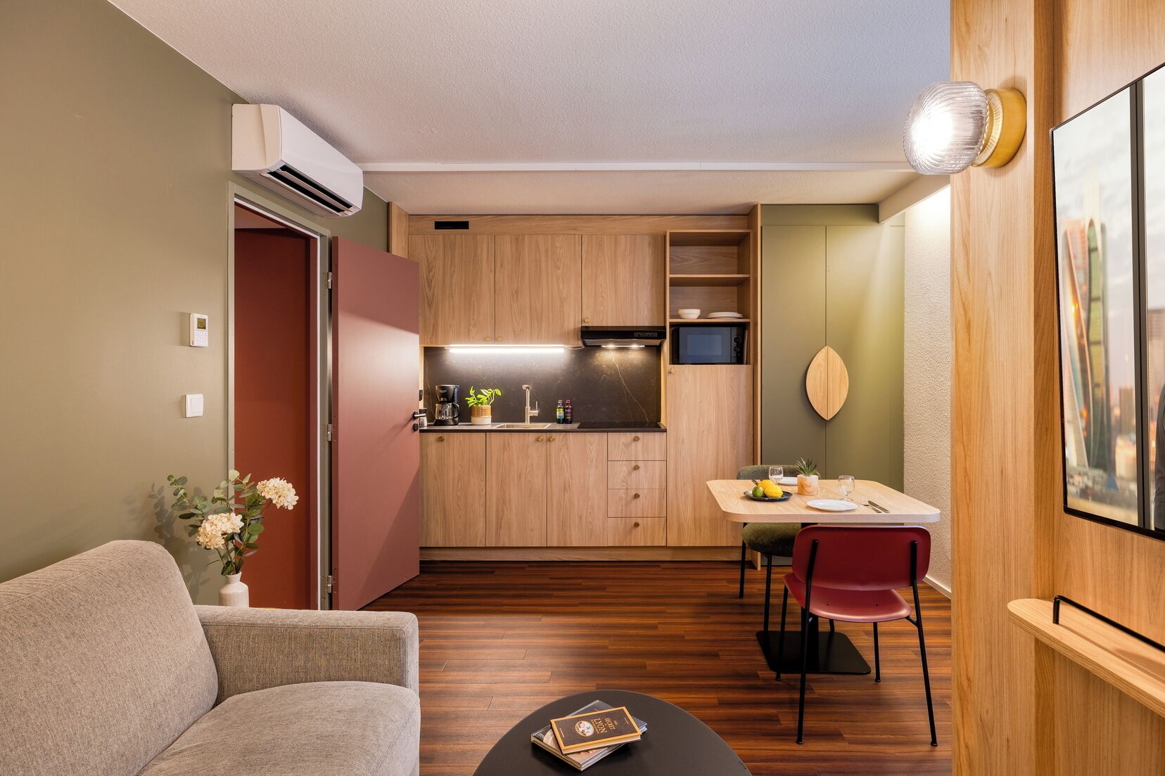 A compact living space with a kitchenette, a dining area, and a seating area.