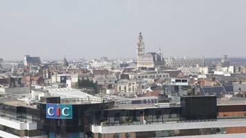 Un paisaje urbano con un edificio CIC destacado, rodeado de otros edificios y una torre a lo lejos.