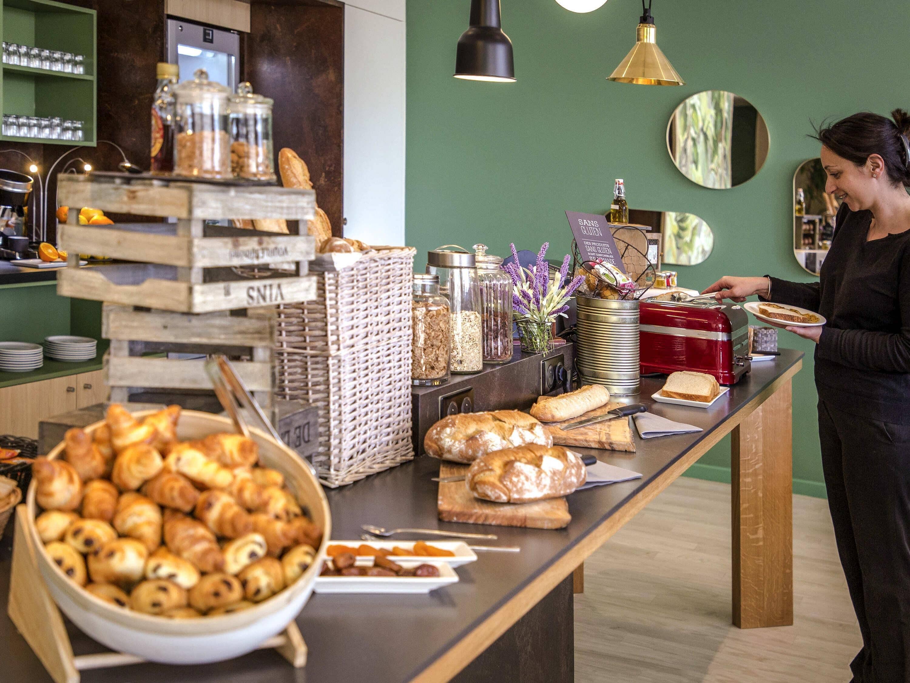 A breakfast buffet with various pastries, bread, and condiments.