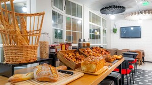 A bakery counter with various breads and pastries, a wicker basket, and condiment bottles. - ibis Paris Ornano Montmartre Nord 18ème (Paris)