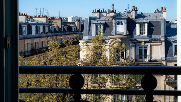A view of a row of residential buildings with distinct architectural styles, including a prominent building with a mansard roof and dormer windows. - ibis Paris Ornano Montmartre Nord 18ème (Paris)