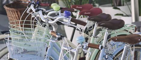 Varias bicicletas con cestas y sillines estacionadas al aire libre.