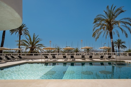 Una piscina al aire libre, sombrillas, guardavidas en la propiedad