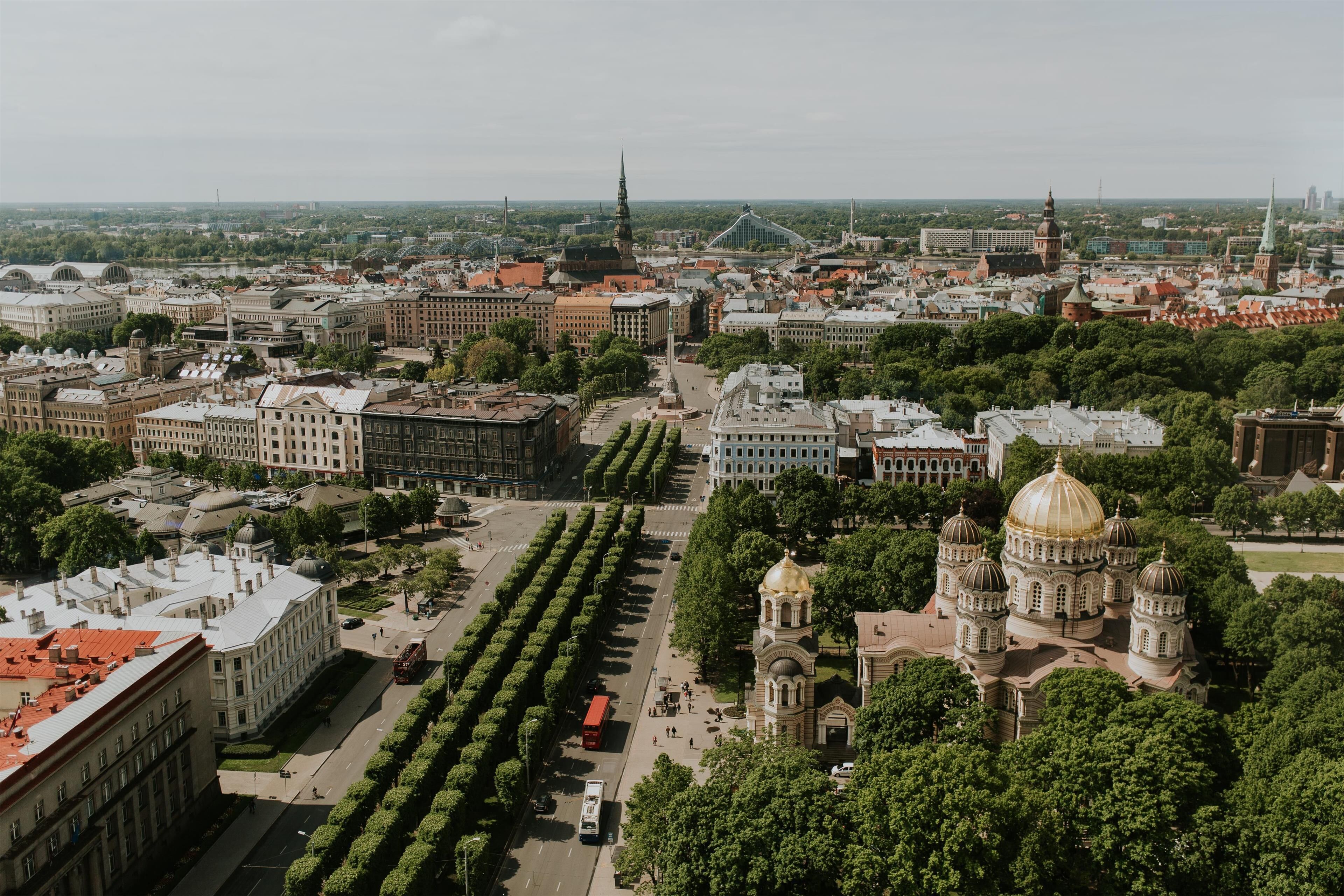 A cityscape with a prominent church with a golden dome, surrounded by trees and buildings.