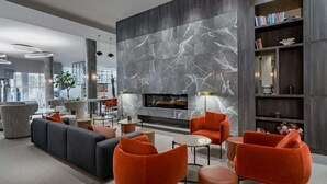 A modern living room with a fireplace, comfortable seating, and a bookshelf.