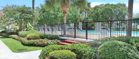 A landscaped area with a pool, a no trespassing sign, and a hotel sign indicating guest-only access.