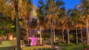 A hotel with a well-lit entrance, palm trees, and a fountain. - Sleep Inn Charleston - West Ashley (Charleston)