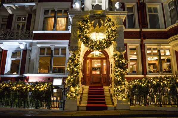 A building with a grand entrance, a staircase leading to the door, and a large wreath above the entrance.