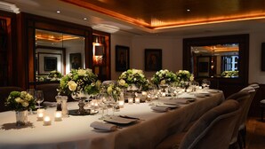 A long dining table set with white tablecloths, candles, and floral centerpieces. - Althoff St. James's Hotel & Club London (London)