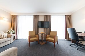Relax in this inviting space with a comfortable sofa, flat-screen TV, and desk for work or leisure.
