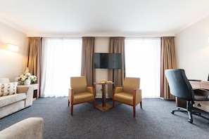 Relax in this inviting space with a comfortable sofa, flat-screen TV, and desk for work or leisure.