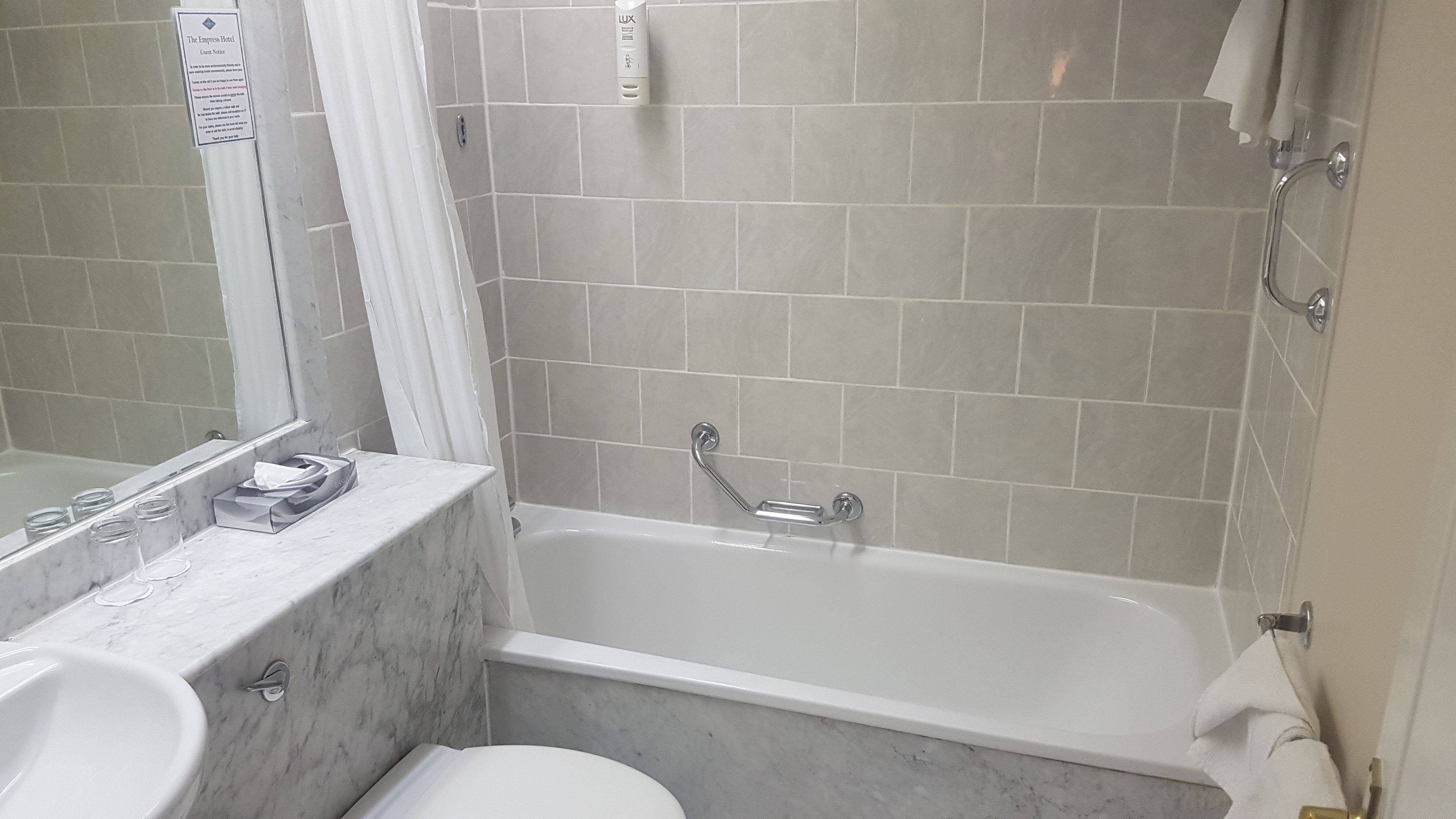 A bathroom with a bathtub, a toilet, and a sink.