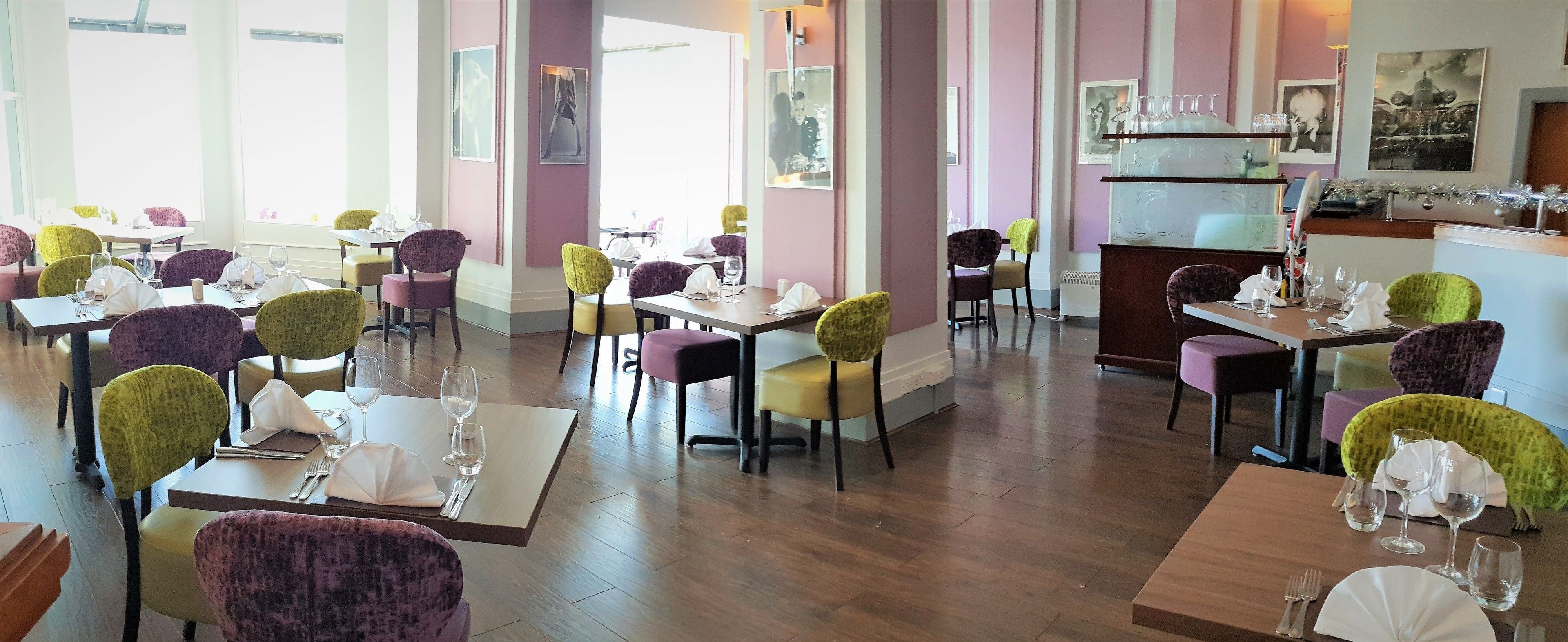 Un restaurant doté de nombreuses tables et chaises, chacune étant mise avec des couverts et des verres à vin.