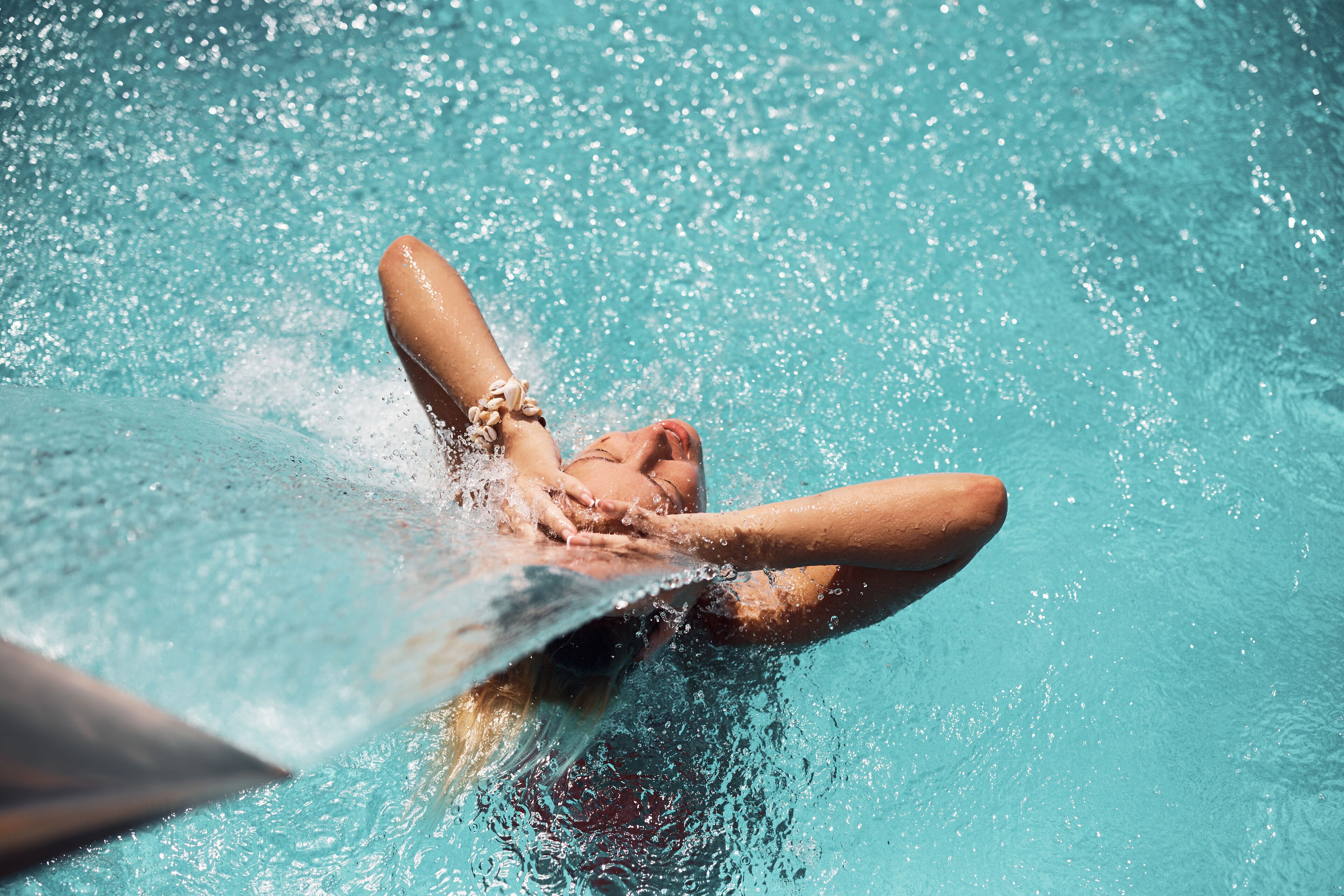 Una persona nadando en una piscina con agua cristalina.