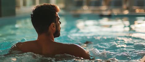 Alberca techada, alberca al aire libre y sombrillas en la alberca