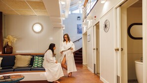 A hotel lobby with a wooden floor, striped walls, a seating area with cushions, and a staircase. - Mercure Hotel & Spa Aix-les-Bains Domaine Marlioz (Aix-les-Bains)