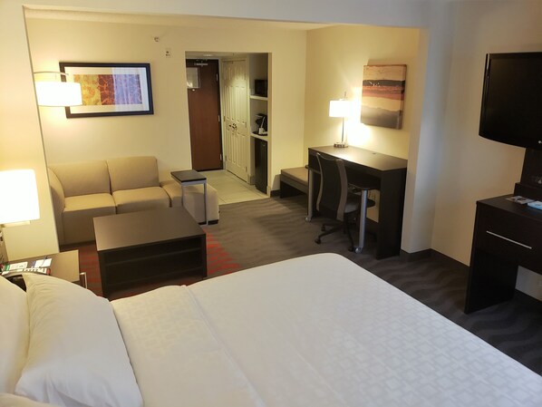 A hotel room with a bed, a desk, a chair, a sofa, and a television. - Holiday Inn Express Portland West/Hillsboro by IHG (Hillsboro)