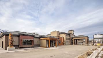 A hotel with a bear statue, a covered entrance, and a sign for the Prestige Golden Hotel.