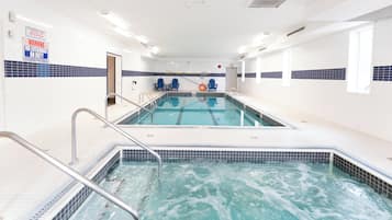 A swimming pool with two lanes, a lifeguard chair, and a no lifeguard on duty sign.