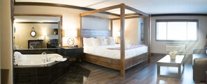 A four-poster bed with a wooden headboard, a large mirror, a bathtub, and a small table with a basket.