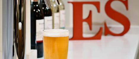 Un grifo con un vaso de cerveza al frente.