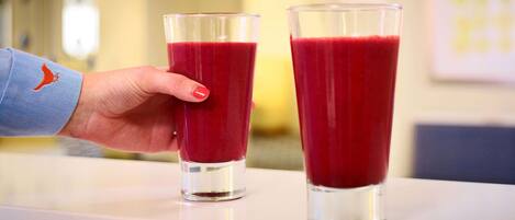 Dos vasos de bebida roja sobre una mesa.