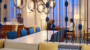 Eine moderne Hotelhalle mit großzügiger Sitzecke, einer Rezeption und einer Treppe.