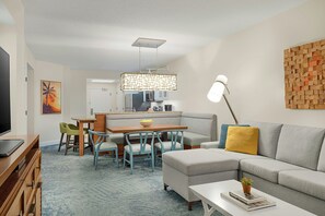 Een moderne woonkamer met een bank, salontafel en een eethoek.