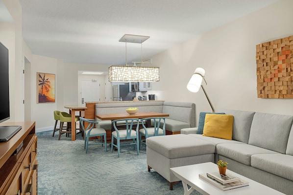 Una sala de estar moderna con sofá, mesa de centro y comedor.
