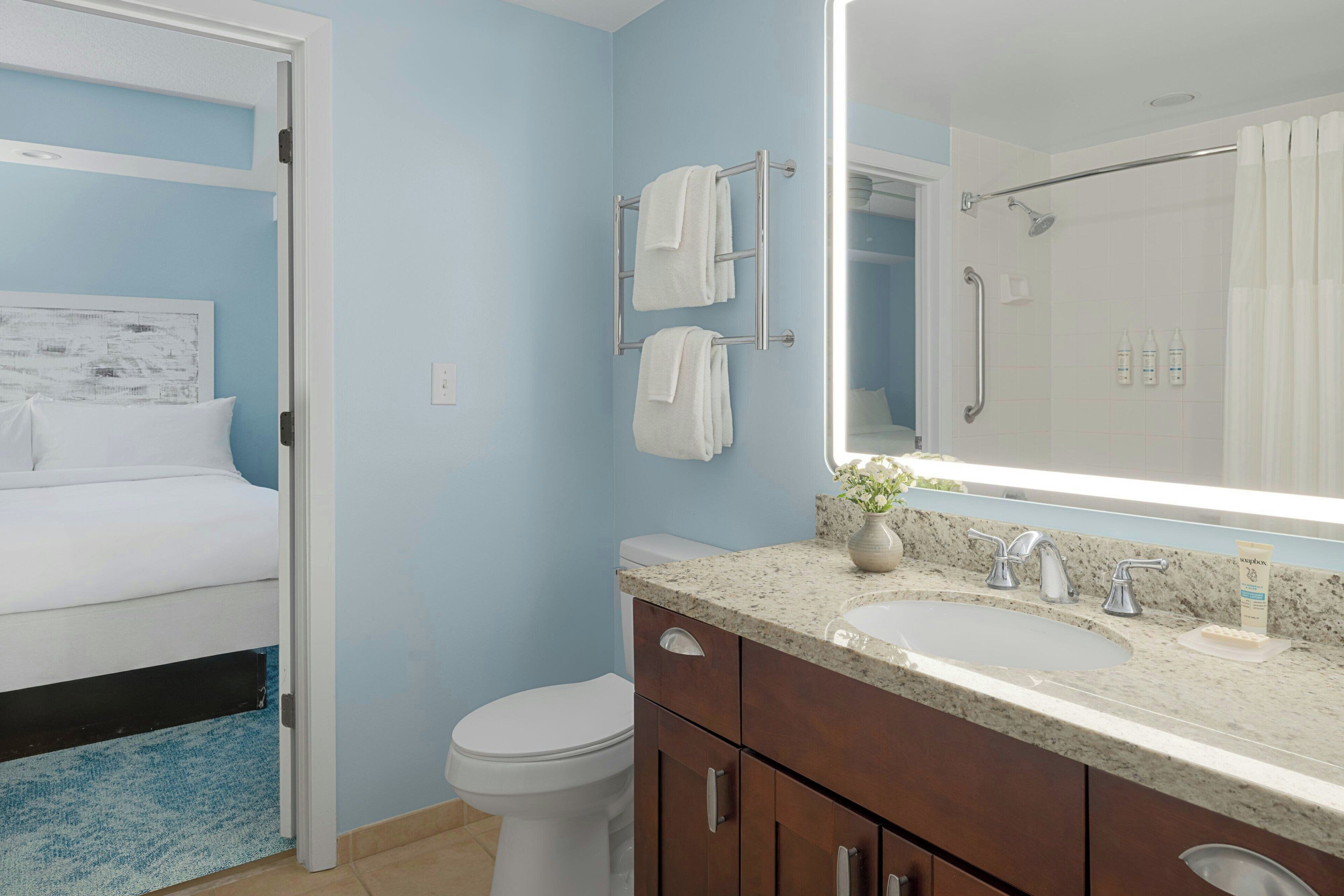 Ein Badezimmer mit Bett, Toilette, Waschbecken und Dusche.